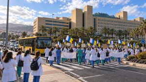Médicos con bata blanca y banderas canarias caminan hacia el Hospital Universitario de Gran Canaria Doctor Negrín durante la huelga de médicos en Canarias